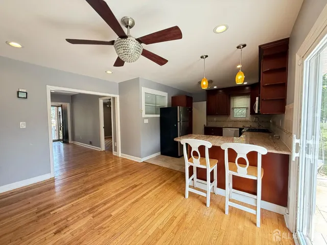 a view of a livingroom with furniture a ceiling fan and wooden floor