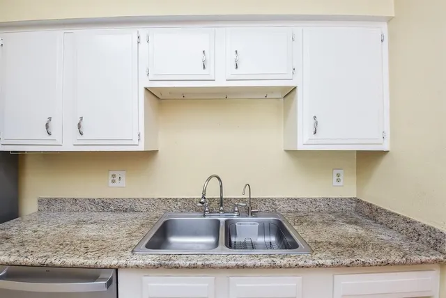 a kitchen with granite countertop a sink and cabinets