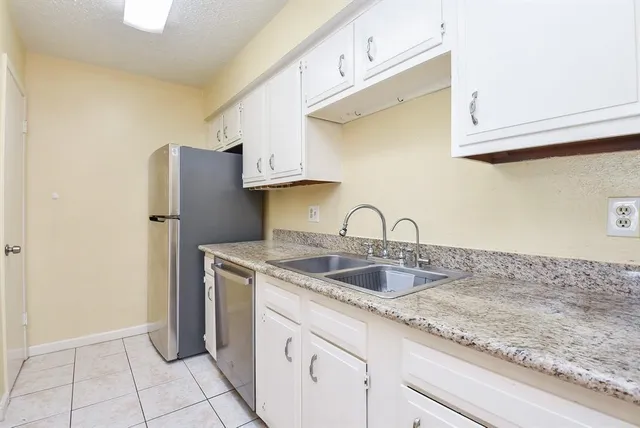 a kitchen with stainless steel appliances granite countertop a sink and a refrigerator