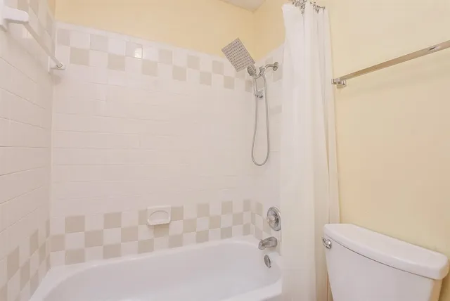 a bathroom with a shower a toilet and a shower