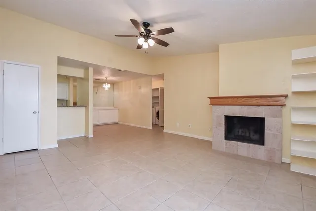 a view of a livingroom with a fireplace and ceiling fan