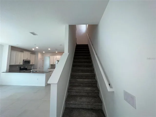 a view of a kitchen with wooden floor and stairs