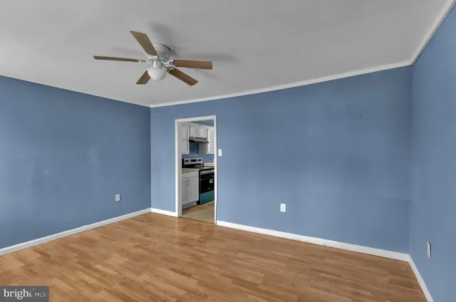 a view of empty room with wooden floor