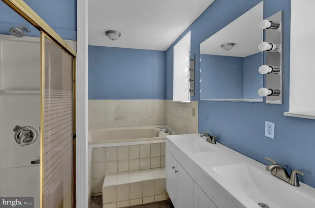 a bathroom with a sink and mirror with bathtub