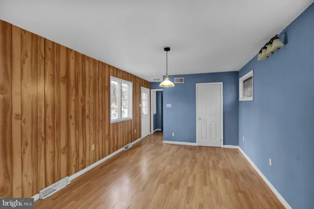 a view of a hallway with wooden floor and chandelier