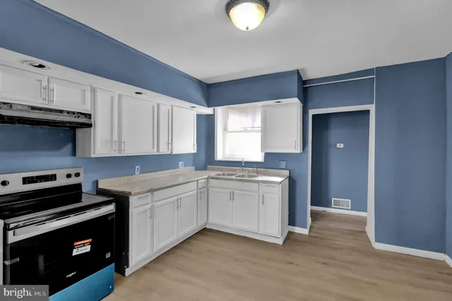 a kitchen with a sink stove and cabinets