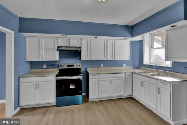 a kitchen with a sink and a stove top oven