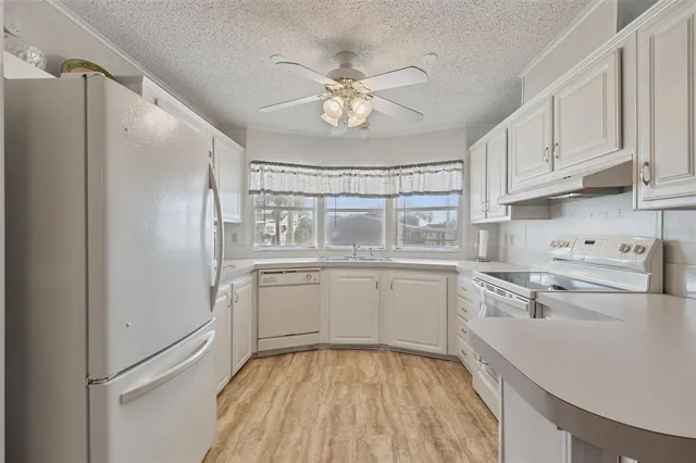 a kitchen with white cabinets and white appliances