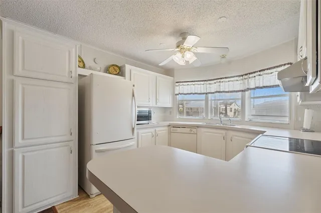 a kitchen with granite countertop a refrigerator a sink and dishwasher