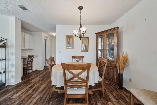 a dining room with furniture a chandelier and wooden floor