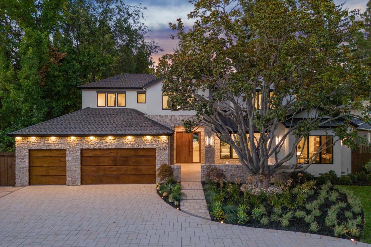 a front view of a house with yard and tree