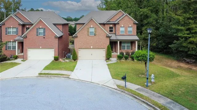 a front view of a house with a yard and trees