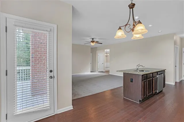 a open kitchen with stainless steel appliances granite countertop a stove and a chandelier