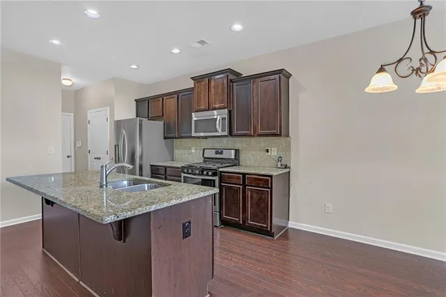 a kitchen with stainless steel appliances granite countertop a sink stove and refrigerator