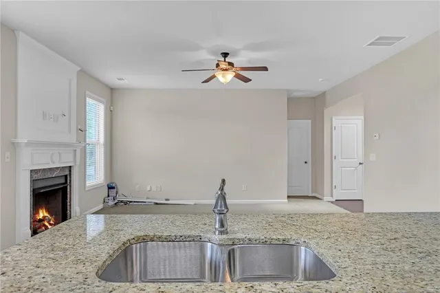 a kitchen with kitchen island a sink granite counter tops and a fireplace