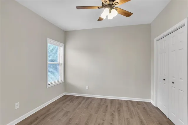 an empty room with a window and a fan