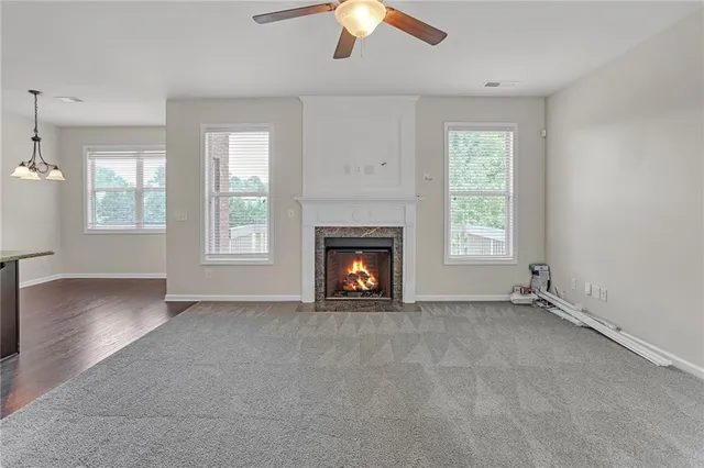 an empty room with windows and fireplace