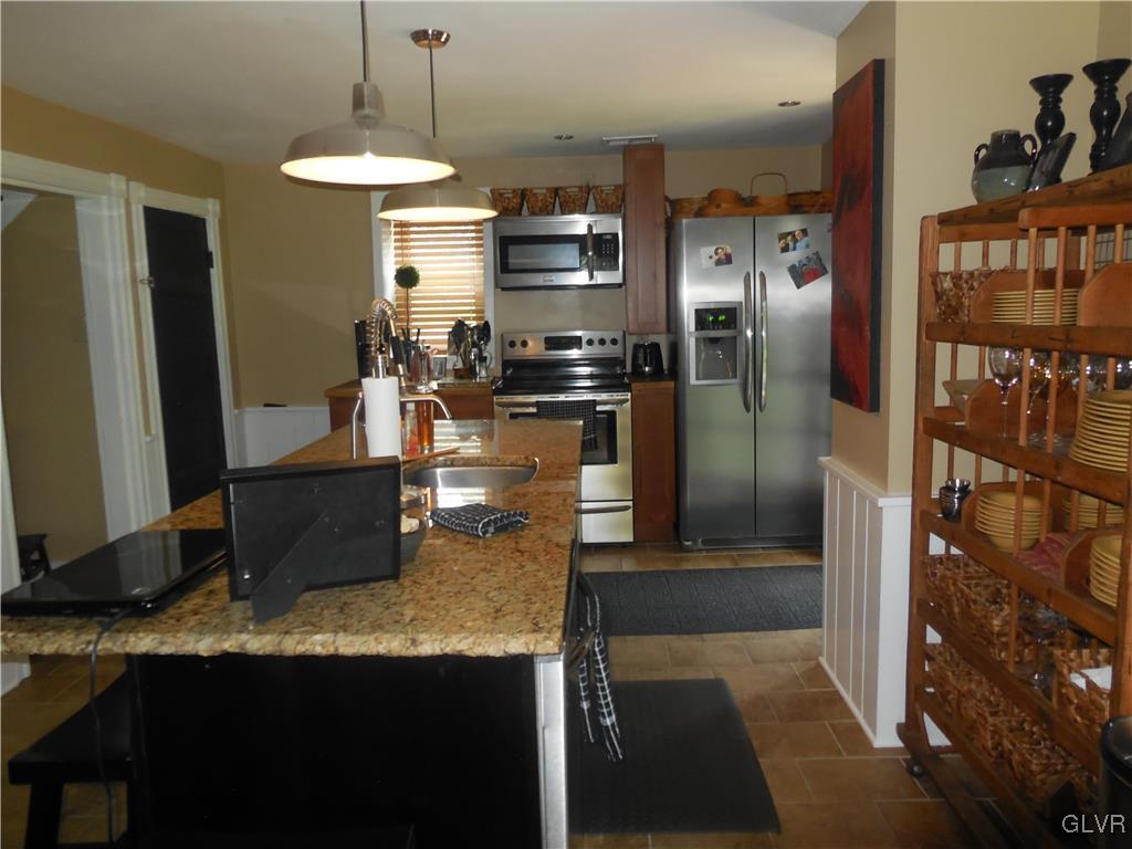 1425 North Brookside Road Lower Macungie Township, PA 18106 - Photo 5 of 31 a kitchen with granite countertop a refrigerator a stove and a sink