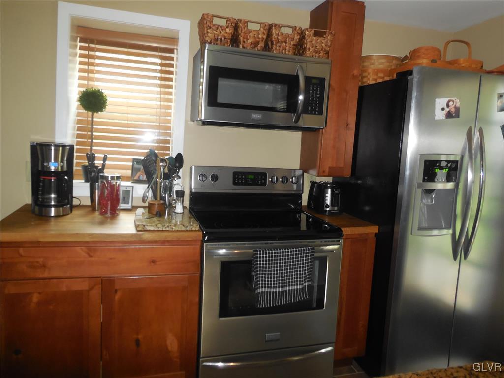 1425 North Brookside Road Lower Macungie Township, PA 18106 - Photo 7 of 31 a kitchen with granite countertop a stove and a microwave