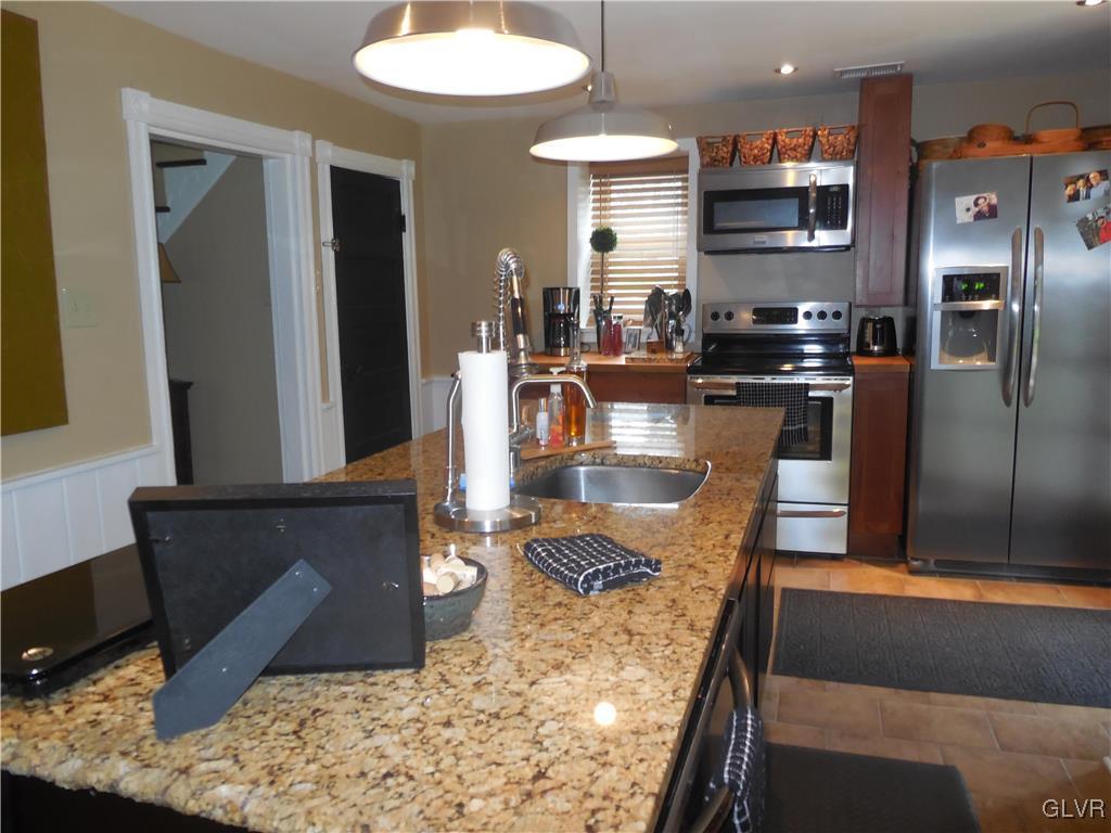 1425 North Brookside Road Lower Macungie Township, PA 18106 - Photo 10 of 31 a kitchen with stainless steel appliances granite countertop a sink and a refrigerator