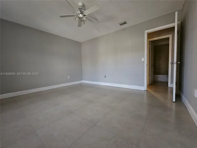 an empty room with a ceiling fan and a window