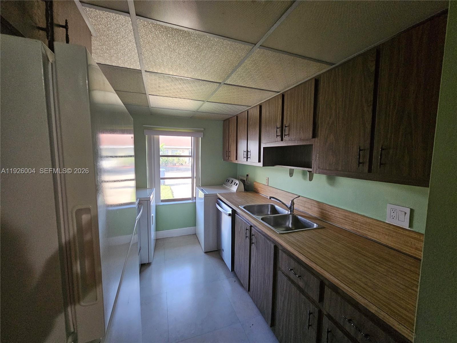5317 Southwest 140th Place, Unit 5317 Miami, FL 33175 - Photo 22 of 30 a kitchen with stainless steel appliances granite countertop a sink and wooden cabinets