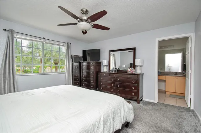 a bedroom with a bed and a large mirror on a dresser