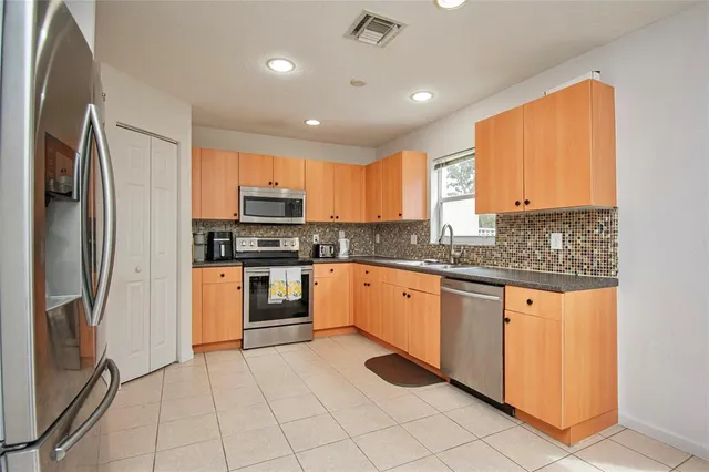a kitchen with stainless steel appliances granite countertop a refrigerator and a stove top oven