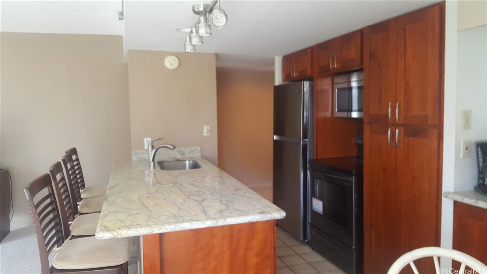240 Makee Road, Unit 5B Honolulu, HI 96815 - Photo 1 of 1 a kitchen with stainless steel appliances granite countertop a refrigerator a stove and a dining table