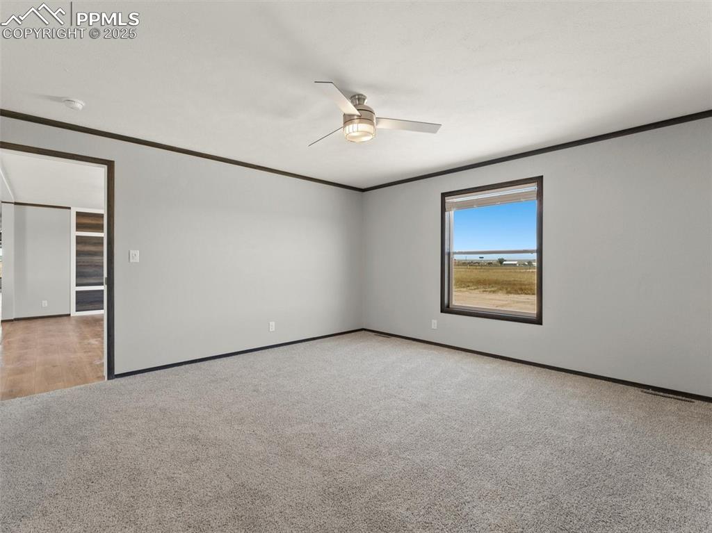 2690 East Ellicott Road South Calhan, CO 80808 - Photo 20 of 46 an empty room with windows and ceiling fan