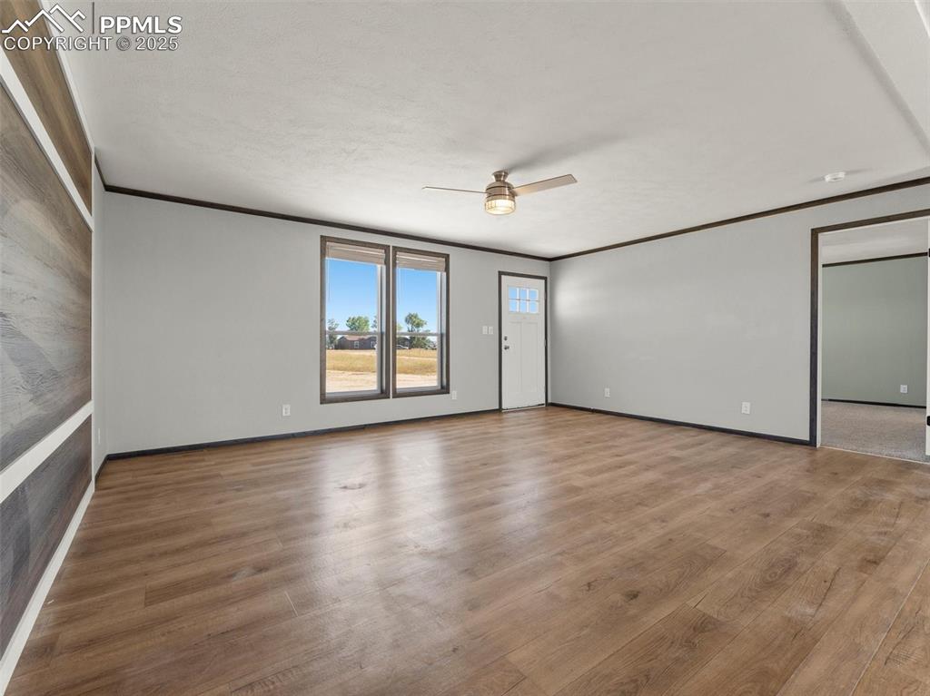 2690 East Ellicott Road South Calhan, CO 80808 - Photo 7 of 46 a view of an empty room with a window and wooden floor