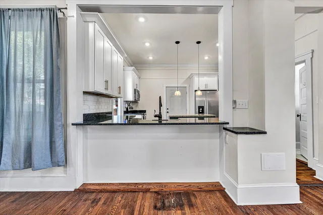 a large kitchen with stainless steel appliances granite countertop a sink and cabinets