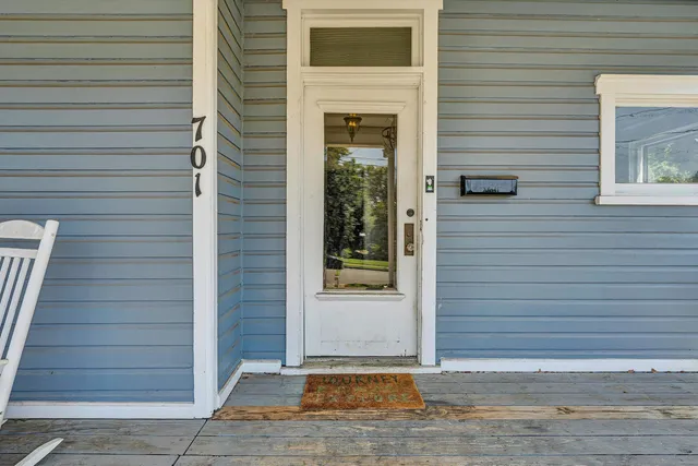 a view of a hallway with wooden floor and windows