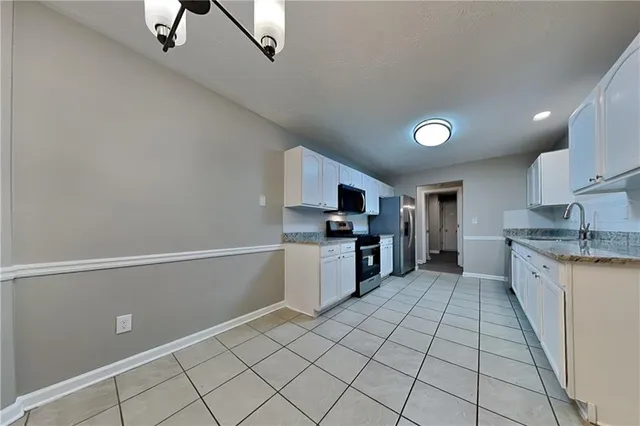 a kitchen with stainless steel appliances granite countertop a refrigerator and a stove top oven