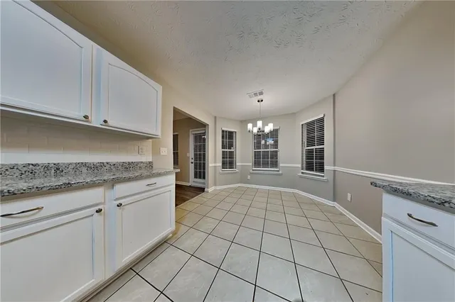 a view of kitchen with granite countertop cabinets and window