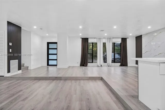 an empty room with wooden floor and entryway