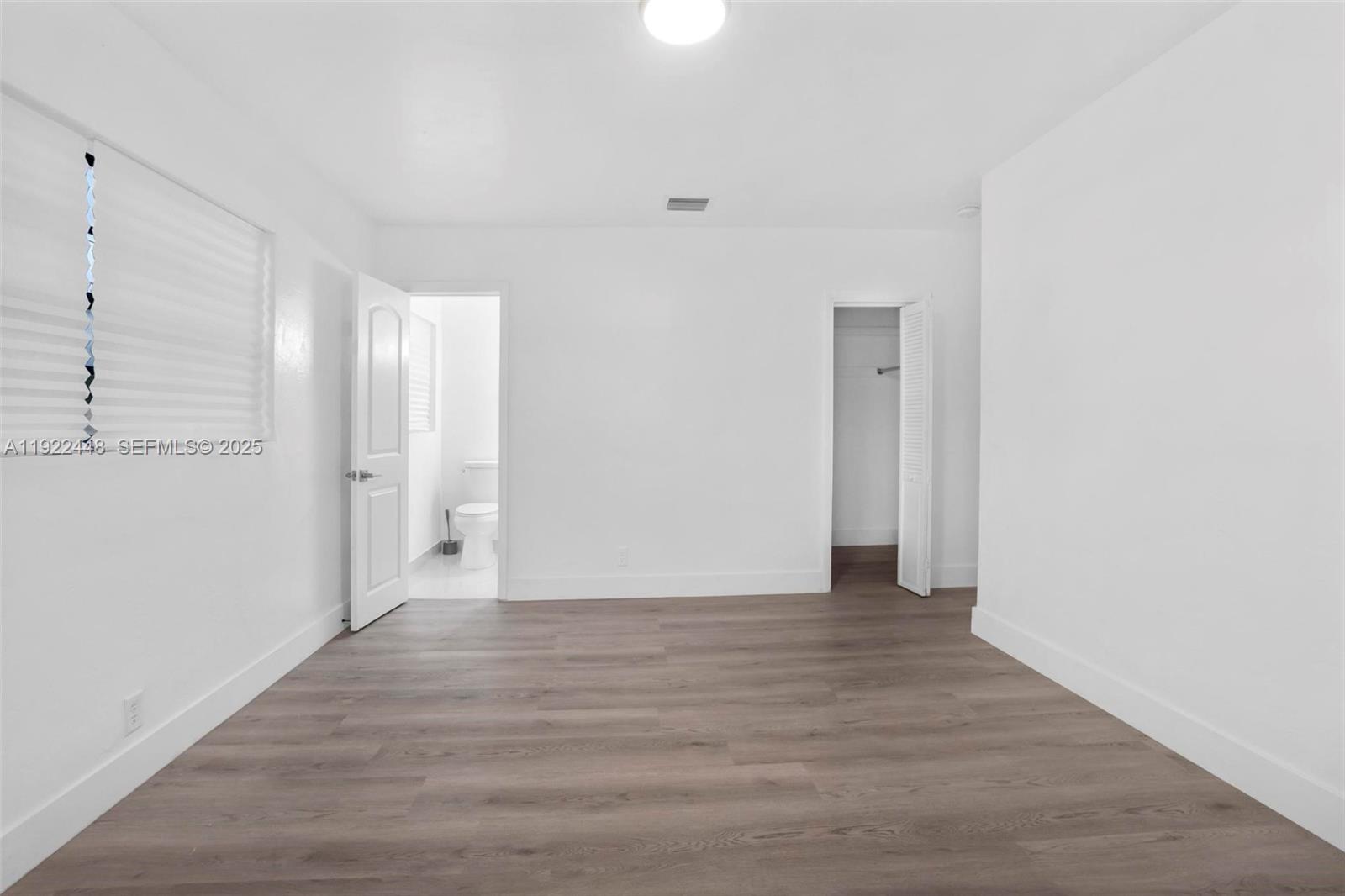 14431 Northwest 13th Road Miami, FL 33167 - Photo 17 of 39 a view of an empty room with wooden floor