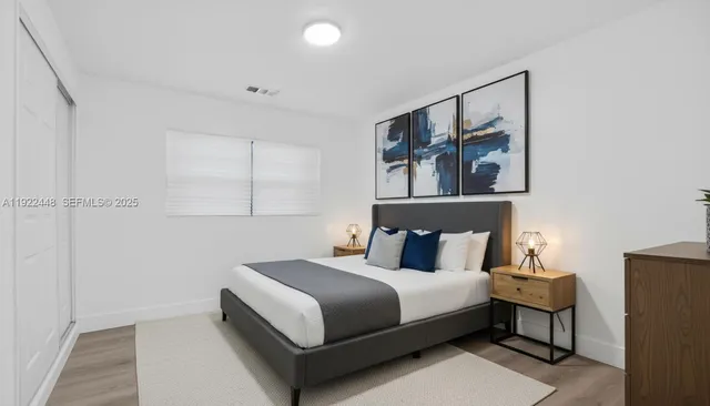 a bedroom with a bed and painting on the wall