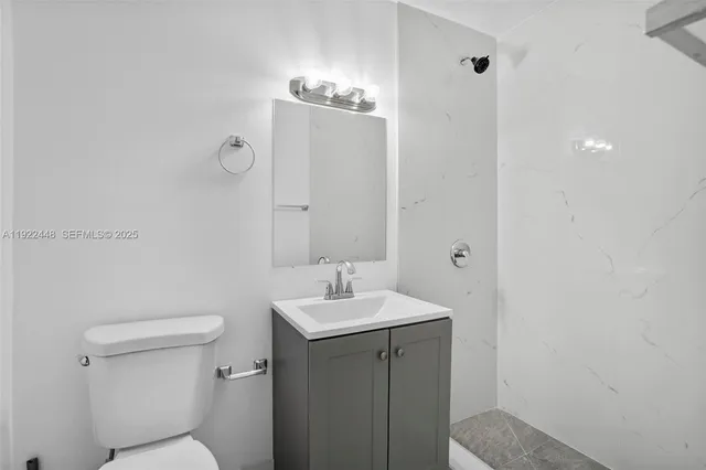 a bathroom with a toilet a sink and mirror