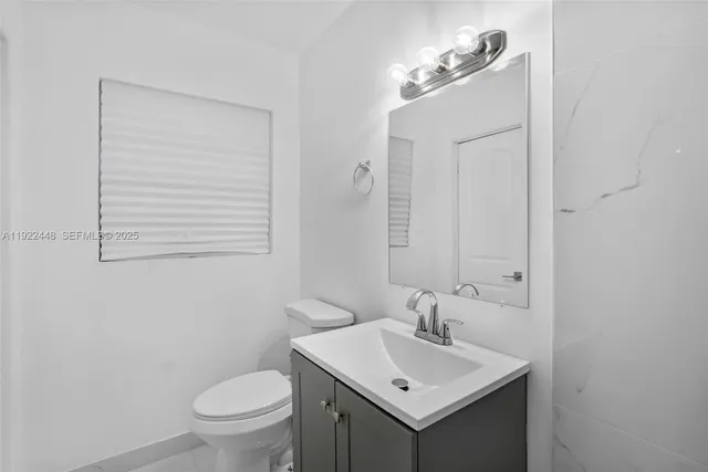 a bathroom with a sink toilet and mirror