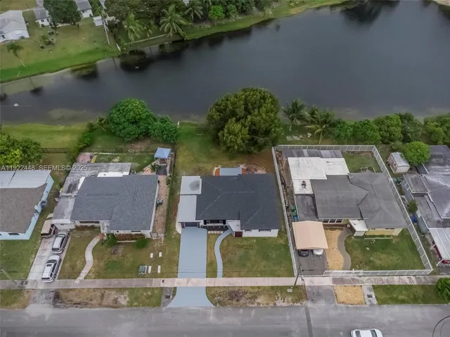 an aerial view of residential houses with outdoor space and parking