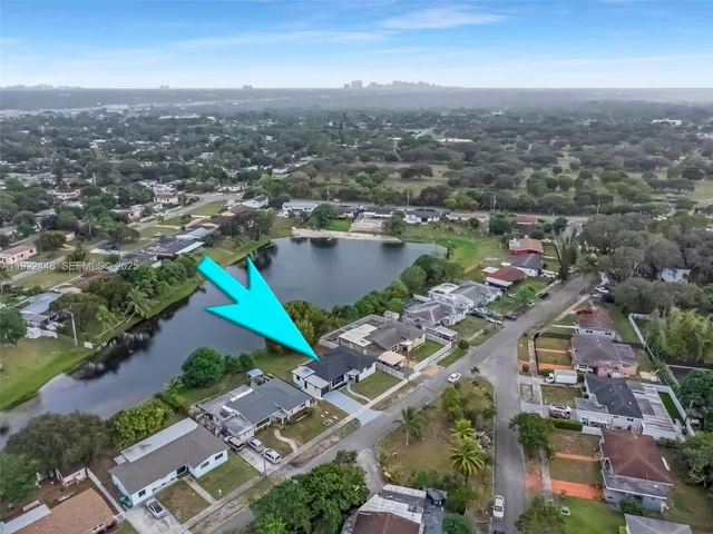 an aerial view of lake and residential houses with outdoor space