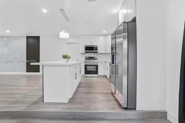 a kitchen with stainless steel appliances a stove top oven a sink and a refrigerator