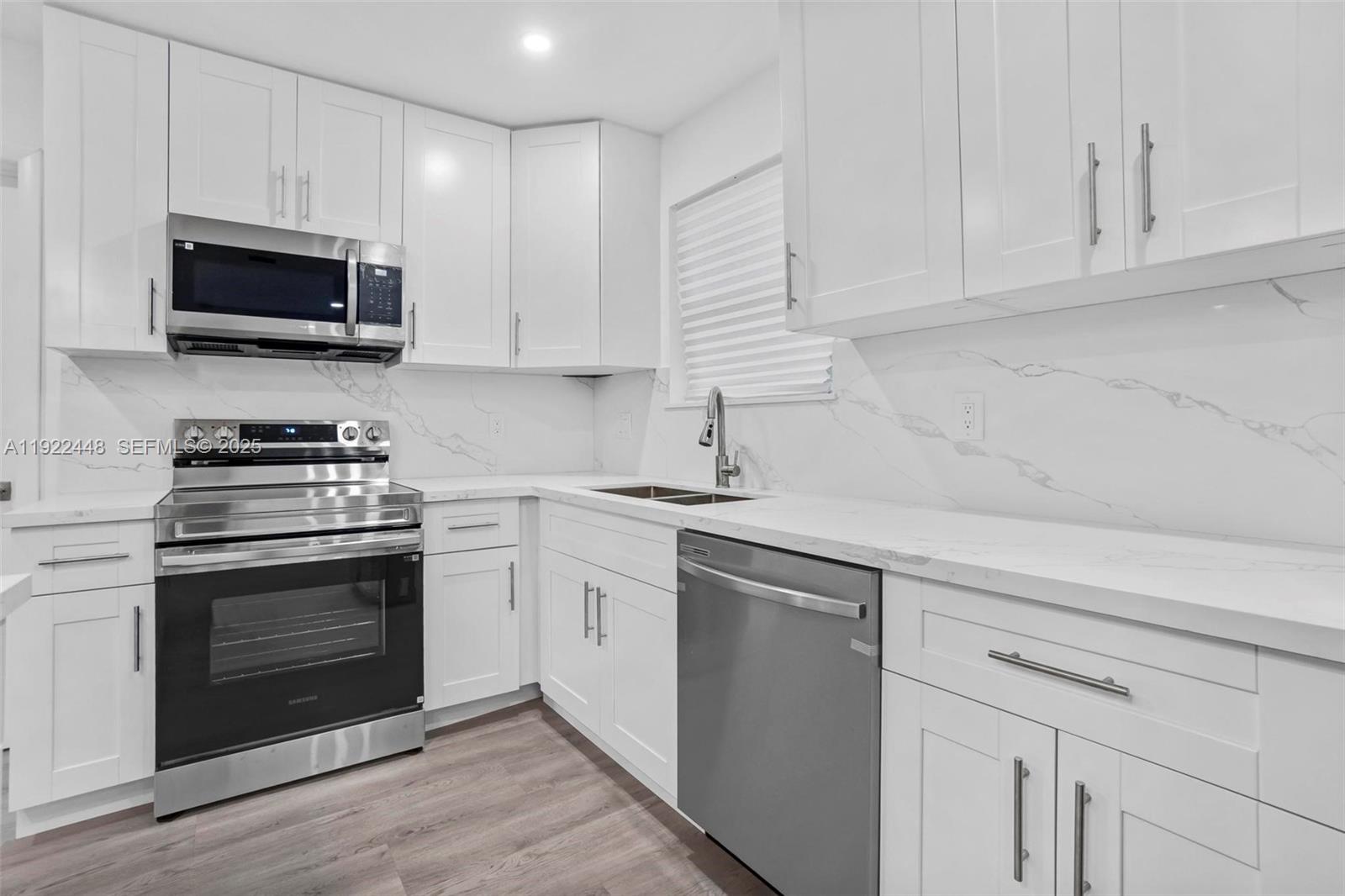 14431 Northwest 13th Road Miami, FL 33167 - Photo 8 of 39 a kitchen with white cabinets stainless steel appliances and sink