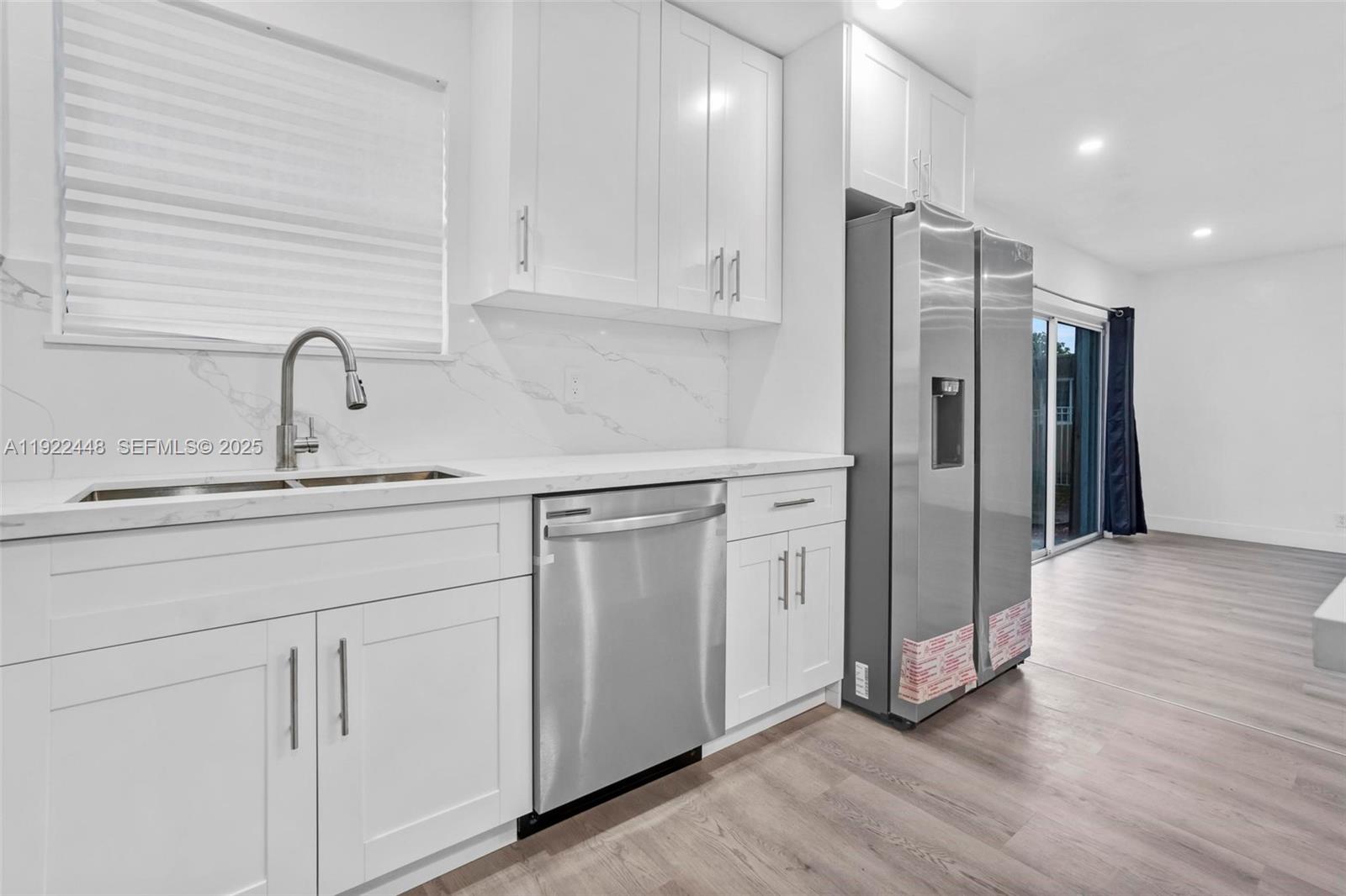 14431 Northwest 13th Road Miami, FL 33167 - Photo 9 of 39 a kitchen with stainless steel appliances a refrigerator sink and cabinets