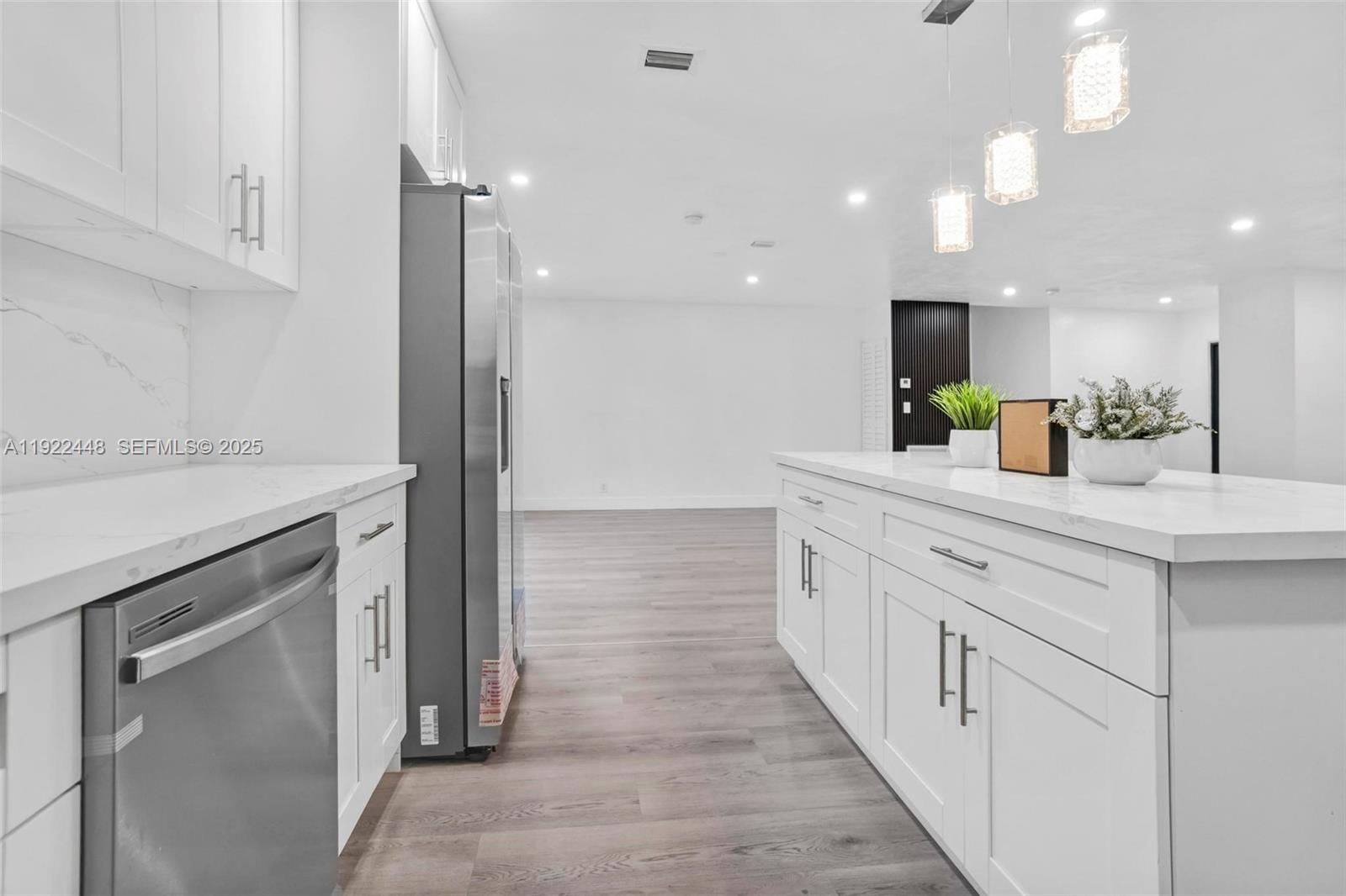 14431 Northwest 13th Road Miami, FL 33167 - Photo 10 of 39 a large white kitchen with a sink and dishwasher a refrigerator with wooden floor