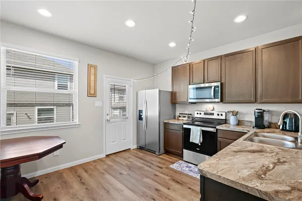 a kitchen with stainless steel appliances granite countertop a refrigerator stove microwave and sink