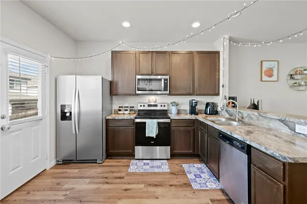 a kitchen with granite countertop stainless steel appliances and wooden cabinets