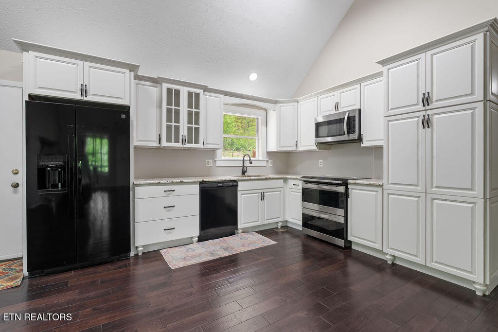 8908 Ellis Lane Powell, TN 37849 - Photo 5 of 37 a kitchen with white cabinets and stainless steel appliances