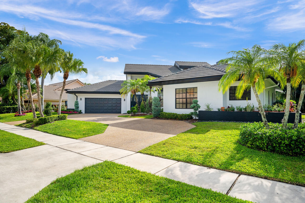 3740 Canterbury Way Boca Raton, FL 33434 - Photo 3 of 55 a front view of a house with a yard and garage